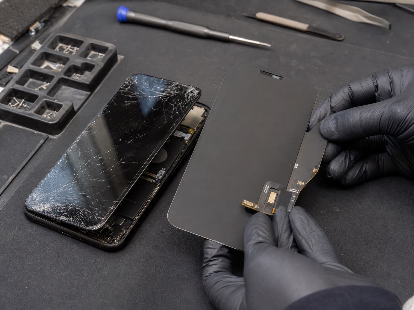 Gebarsten telefoonscherm en vervangend display tijdens een iPhone 16 schermreparatie